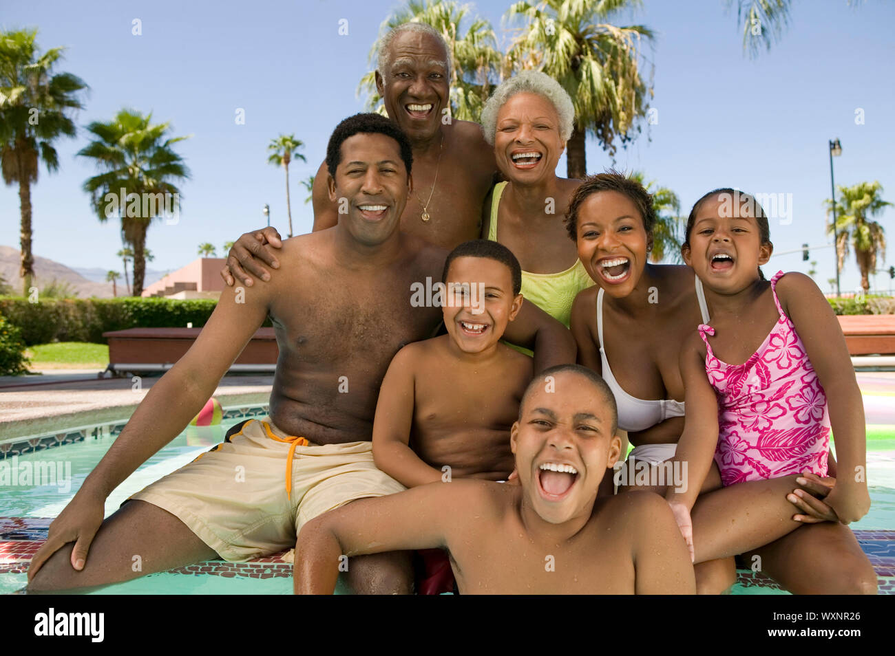 Family Relaxing Poolside Stock Photo