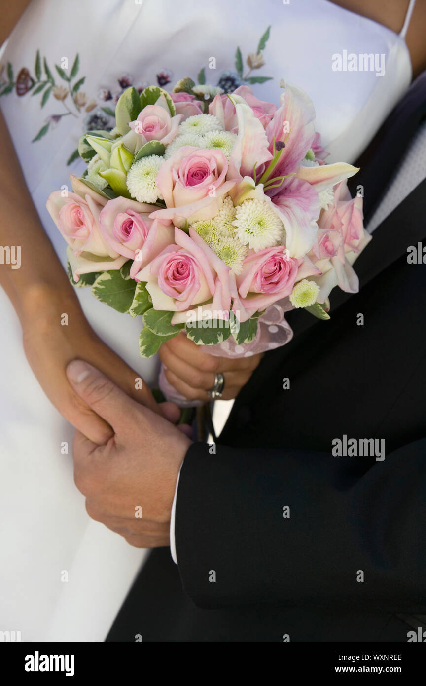 Bride and Groom Holding Hands and Bouquet Stock Photo - Alamy