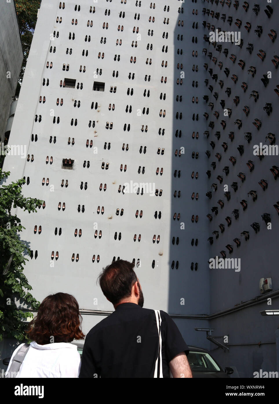 Istanbul, Turkey. 17th Sep, 2019. People watch a facade of a building installed with high heels in downtown Istanbul, Turkey, Sept. 17, 2019. A total of 440 pairs of high-heel black shoes were installed recently on a facade of a building in downtown Istanbul to draw attention to the equal number of women murders in Turkey last year and raise awareness against increasing male violence in the country. Credit: Xu Suhui/Xinhua/Alamy Live News Stock Photo