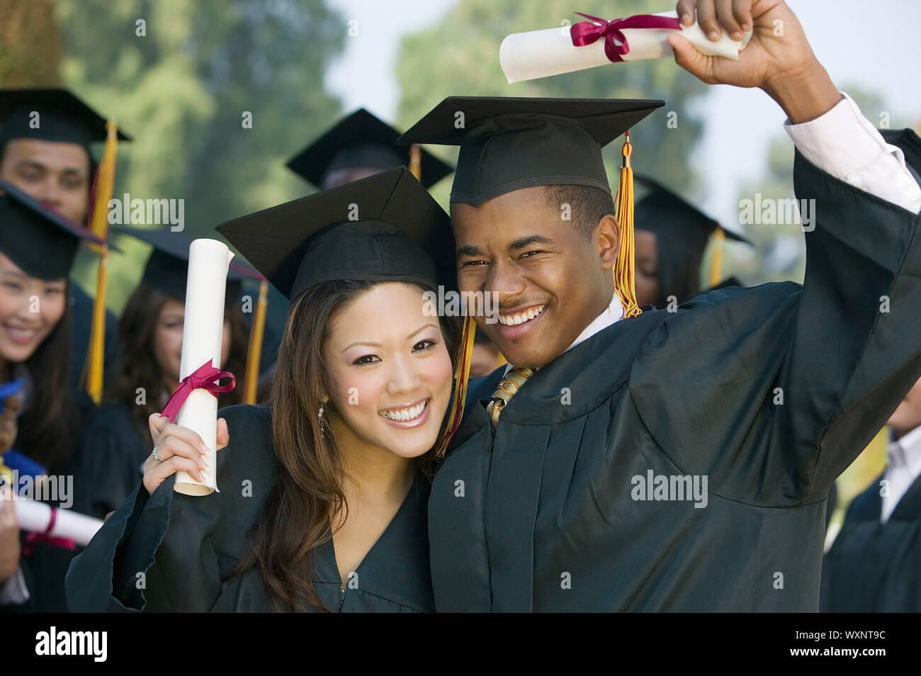 Happy Graduates with Diplomas Stock Photo