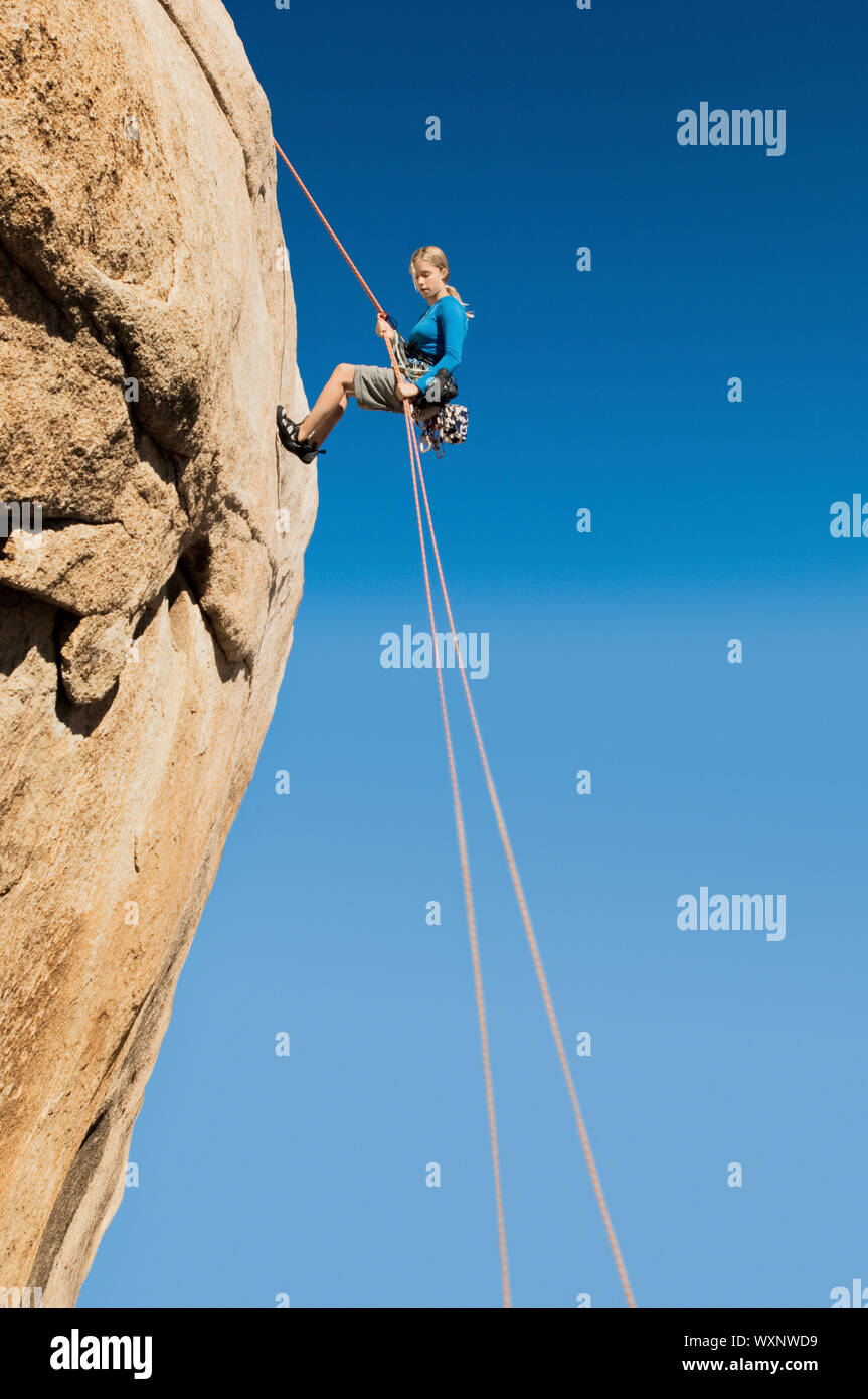 Woman Rappelling on Cliff Stock Photo Alamy