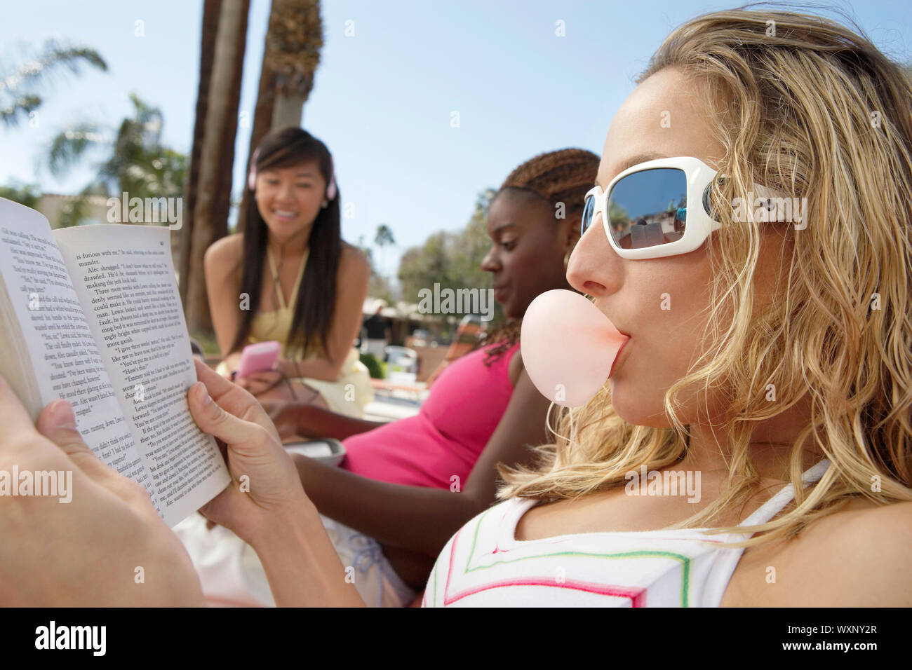 Three Young Women Relaxing Outdoors Stock Photo