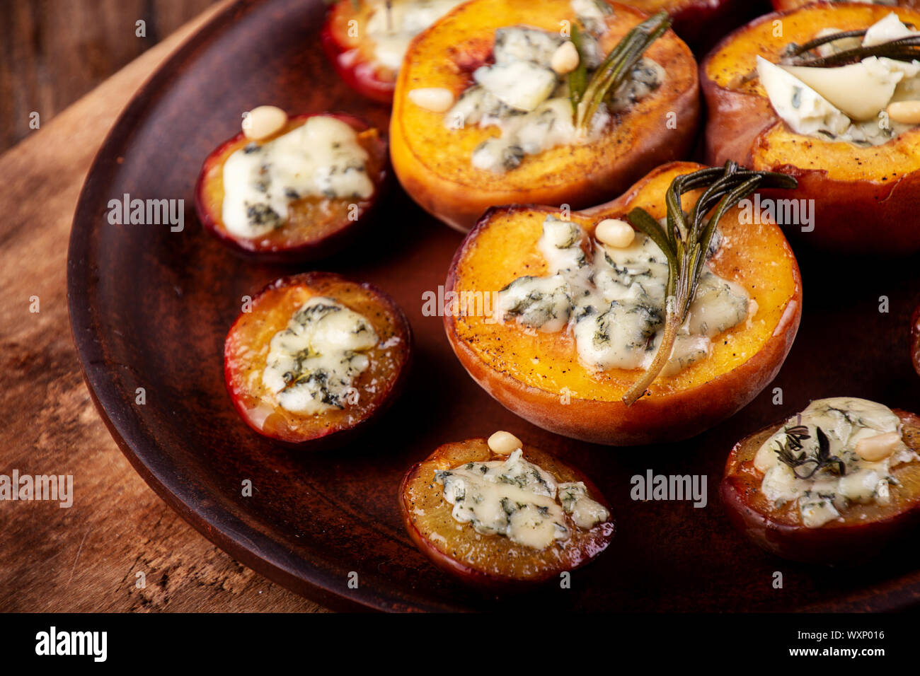 Grilled baked peach and plums stuffed with blue cheese dorblu and