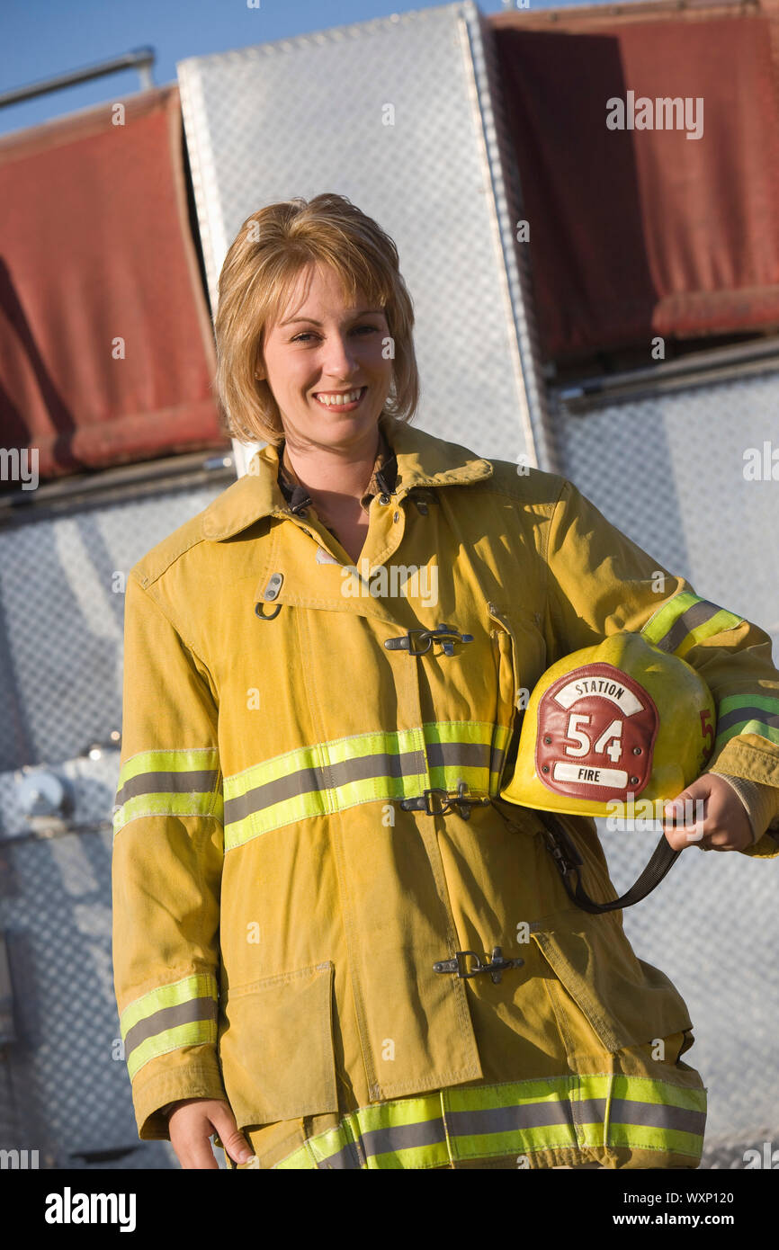 Portrait of female firefighter holding helmet Stock Photo - Alamy