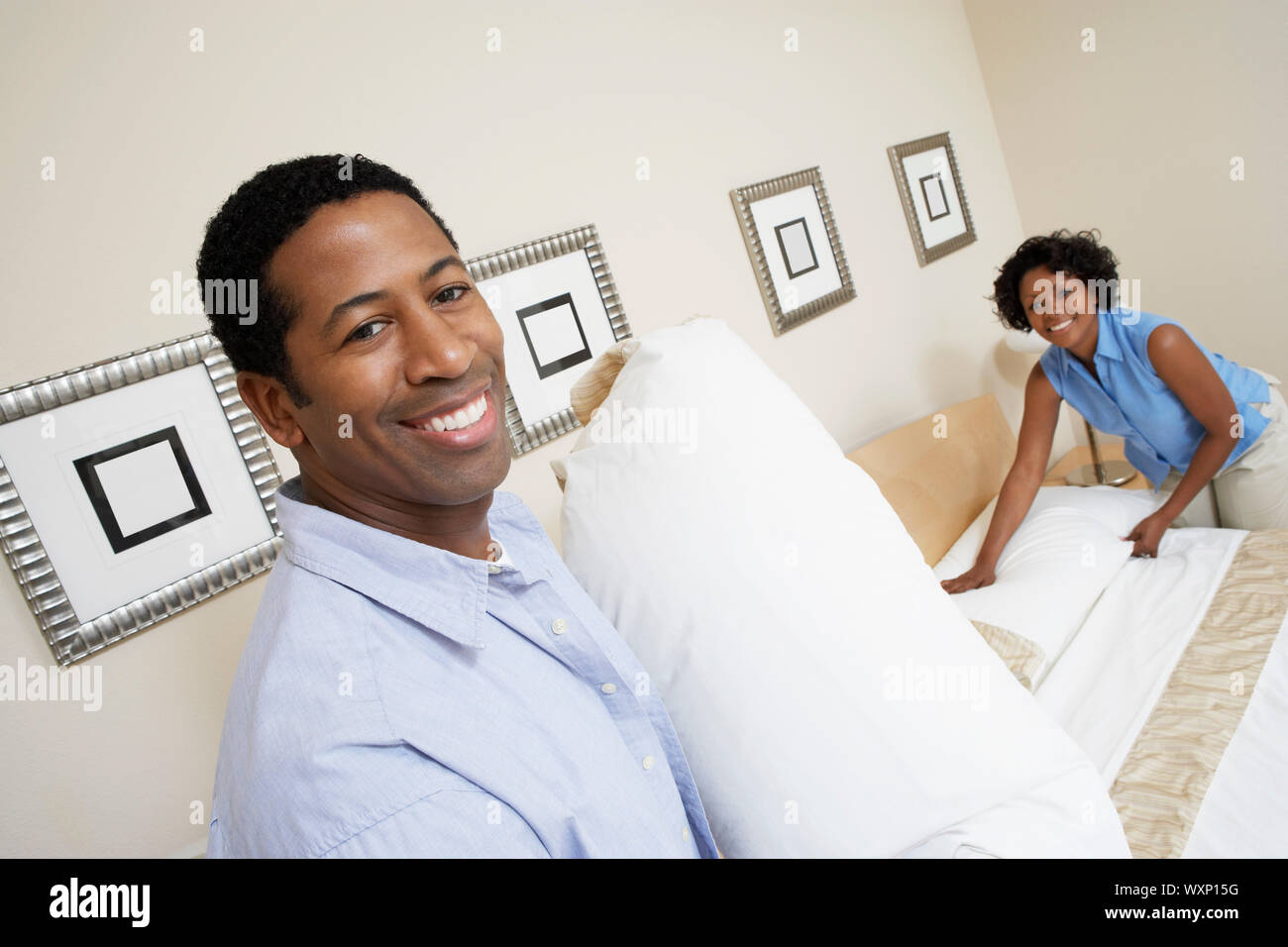 Couple Making Bed Stock Photo