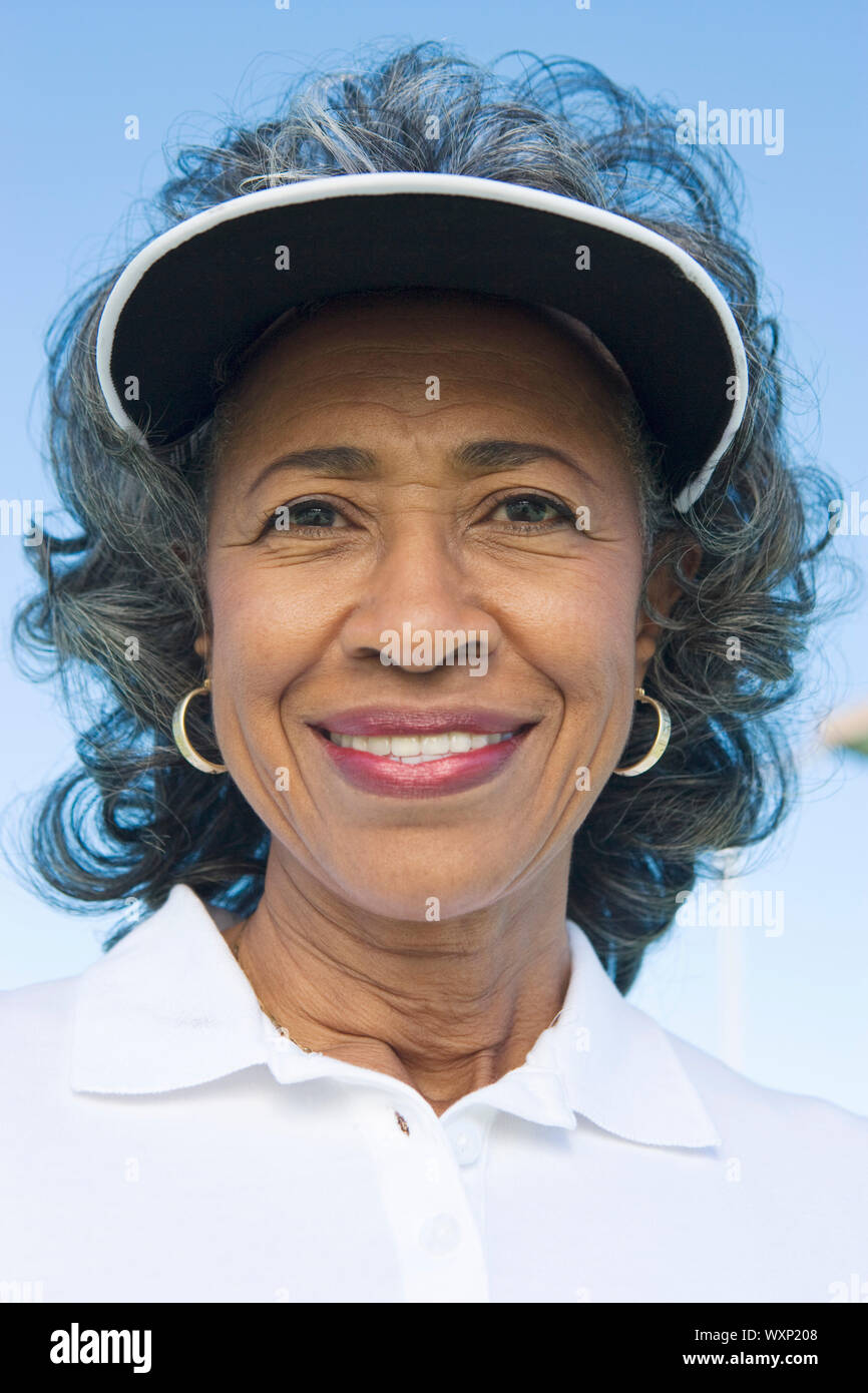 Woman wearing sun visor, portrait Stock Photo Alamy