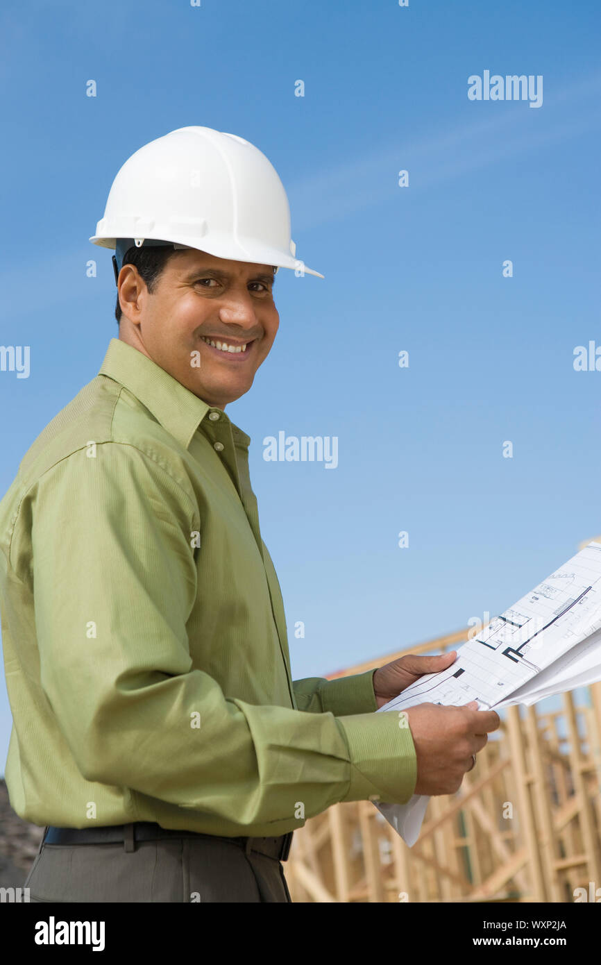 Architect holding blueprints on construction site Stock Photo Alamy