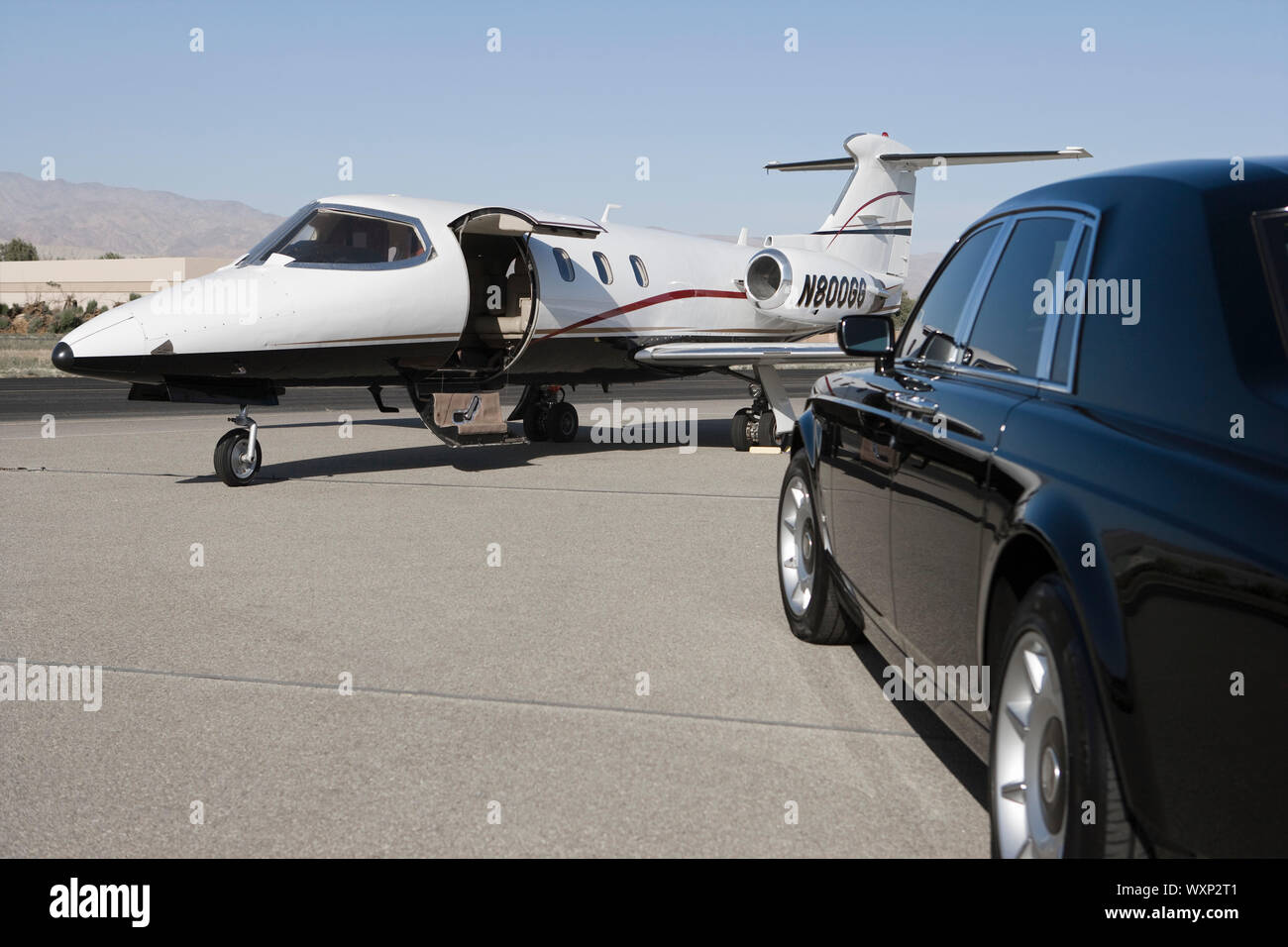 Limousine and private jet on landing strip Stock Photo Alamy