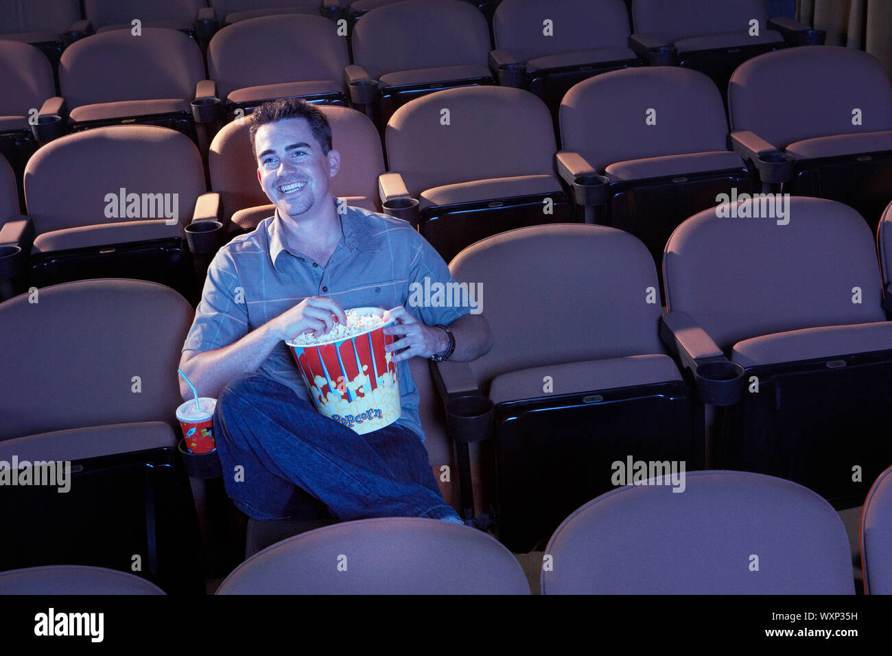 Man Watching Movie in Empty Theater Stock Photo
