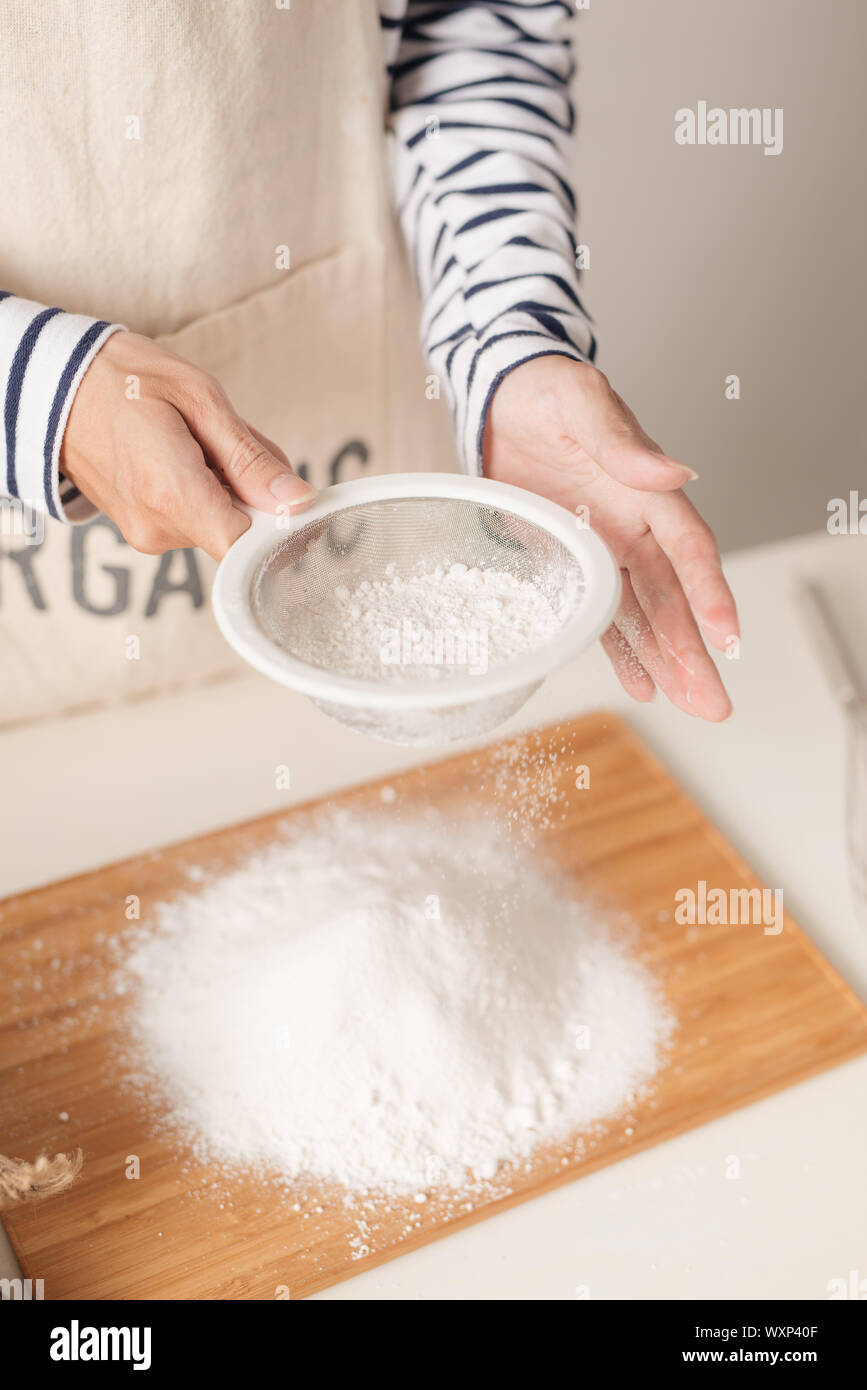 Flour sifting through a sieve for a baking Stock Photo Alamy