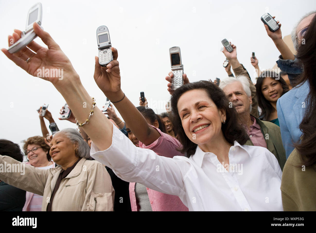Crowd holding up mobile phones Stock Photo - Alamy