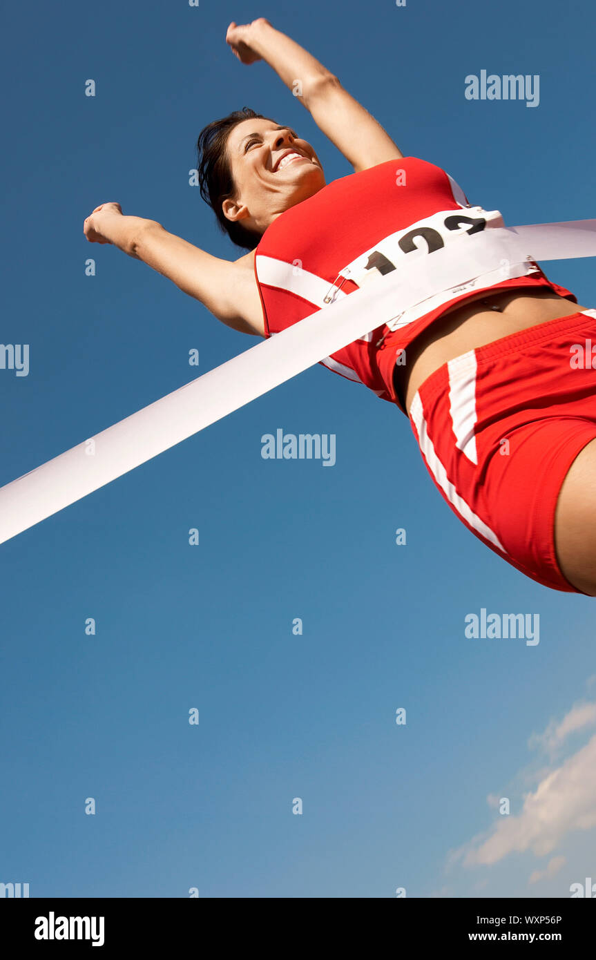 Woman runner breaking tape hi-res stock photography and images - Alamy