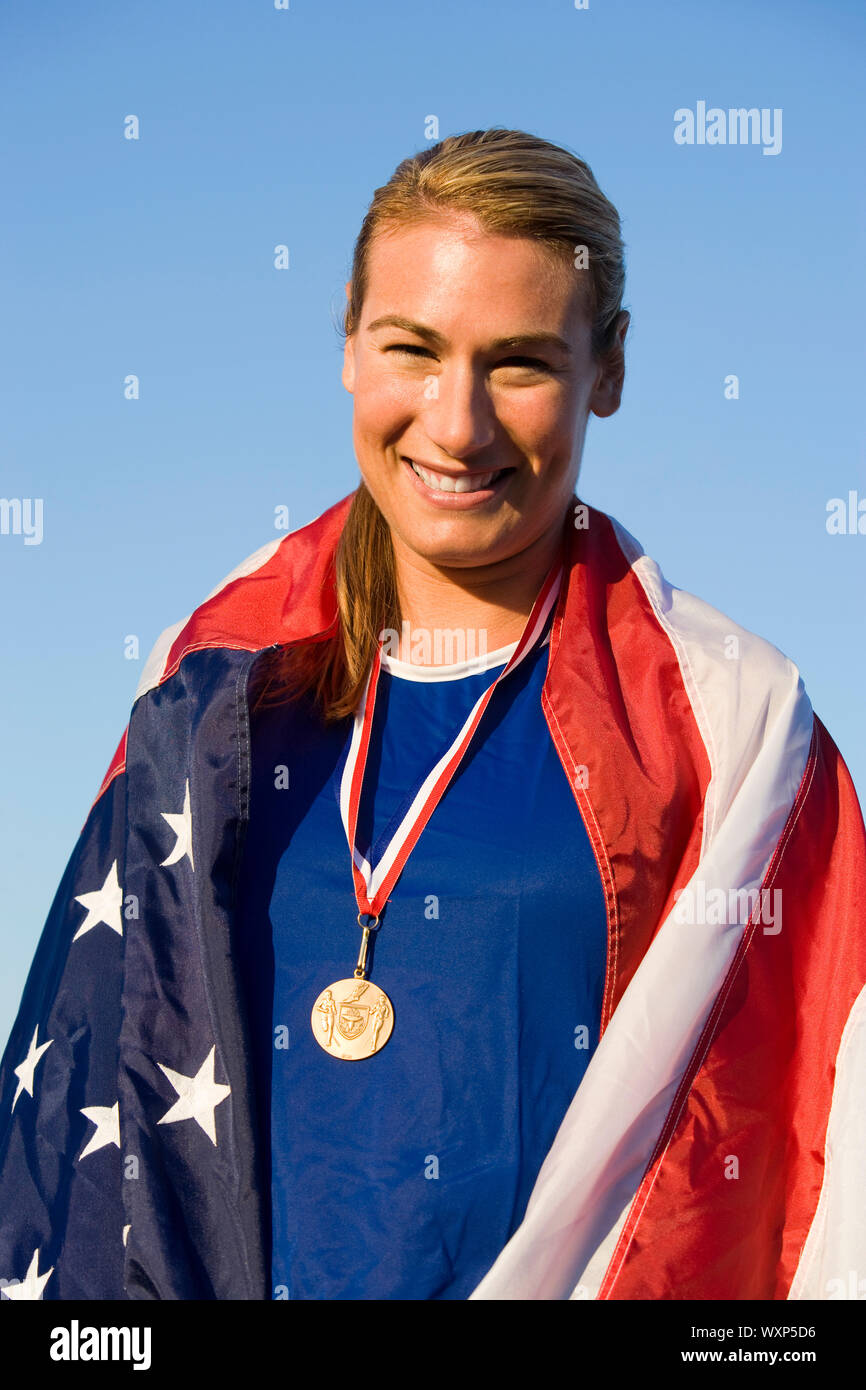 Female athlete wrapped in american flag with golden medal on neck Stock ...