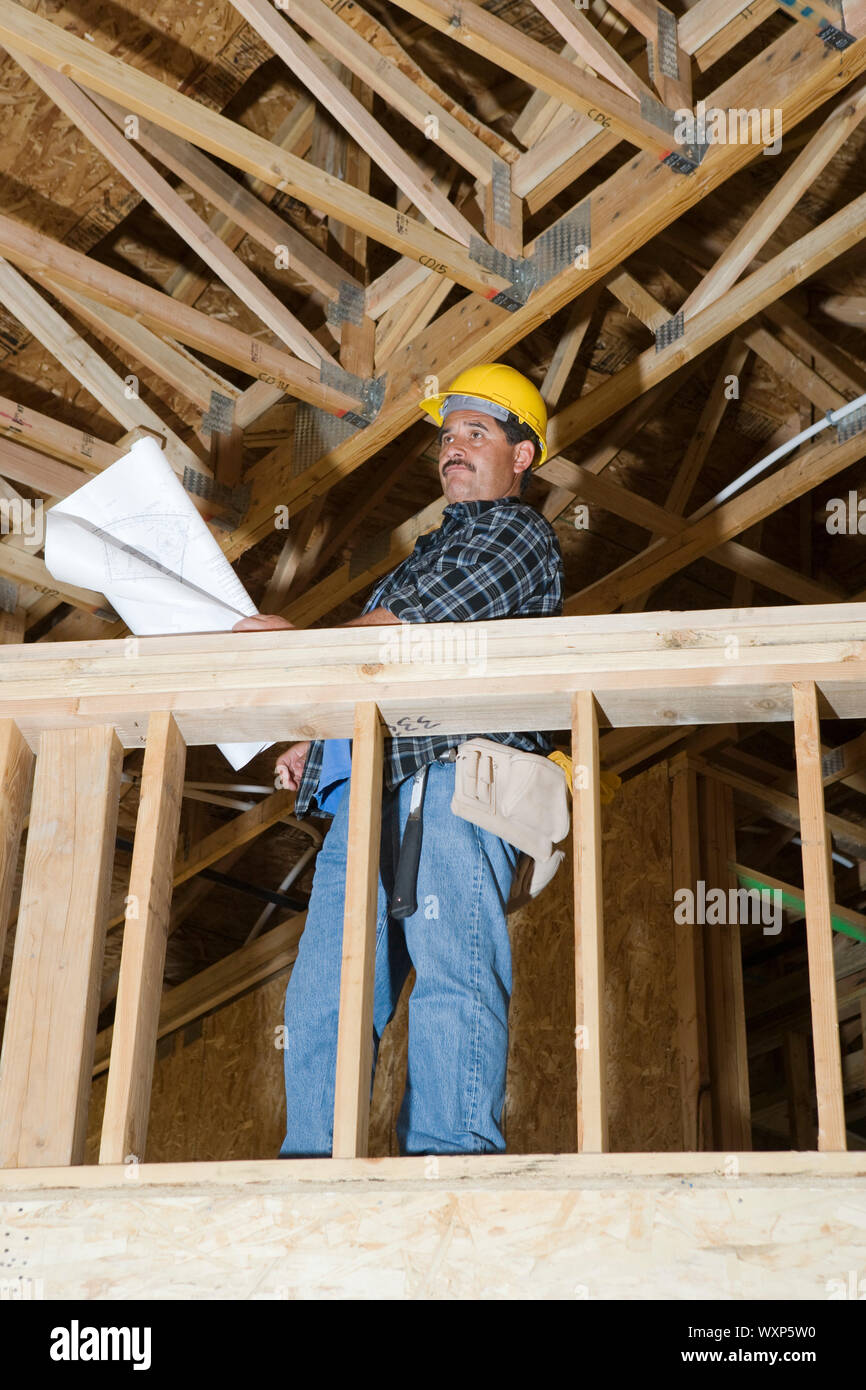 Worker holding blueprint in construction site Stock Photo - Alamy