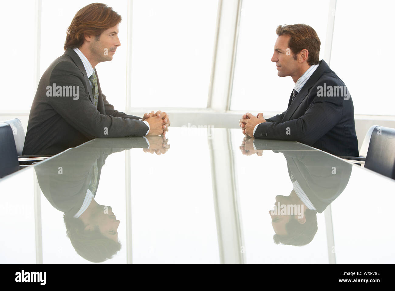 Side view of businessmen looking at each other in conference room Stock ...