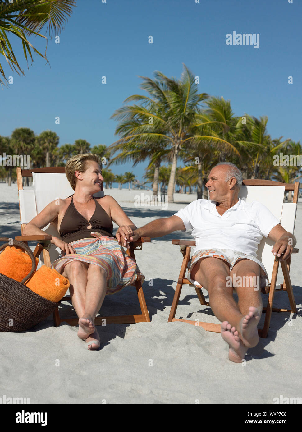 Couple sitting in deckchairs on the beach hi-res stock photography and ...