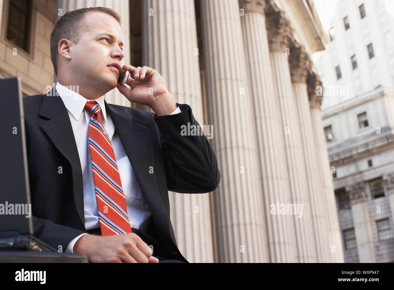 Confident mature businessman using cell phone in front of building Stock Photo