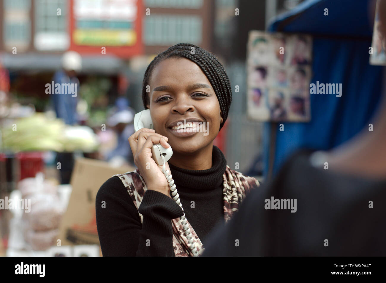African or black American woman calling on landline telephone in Alexandra township Stock Photo