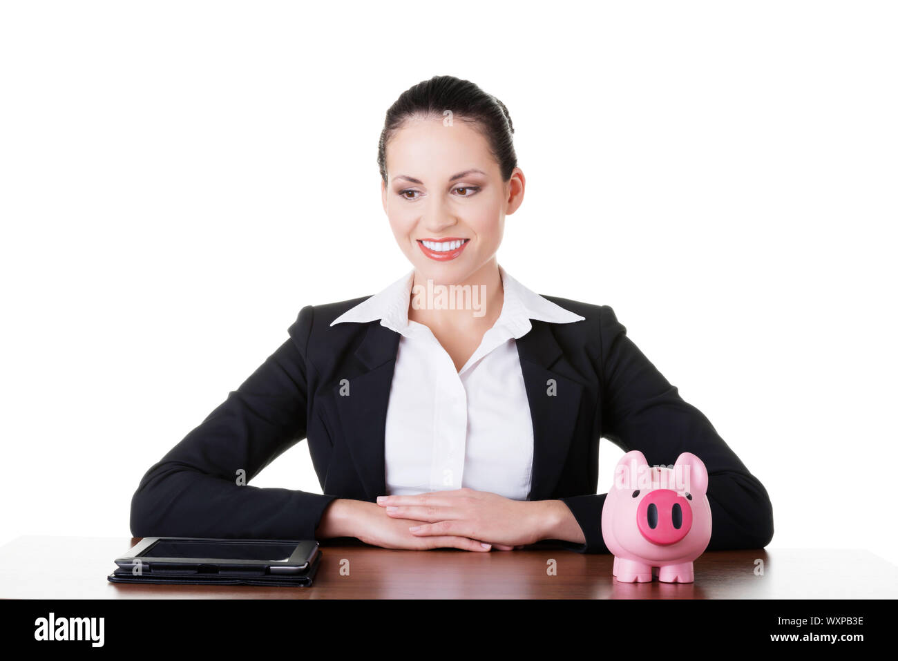 Businesswoman at the desk with tablet and piggy bank, isolated on white ...