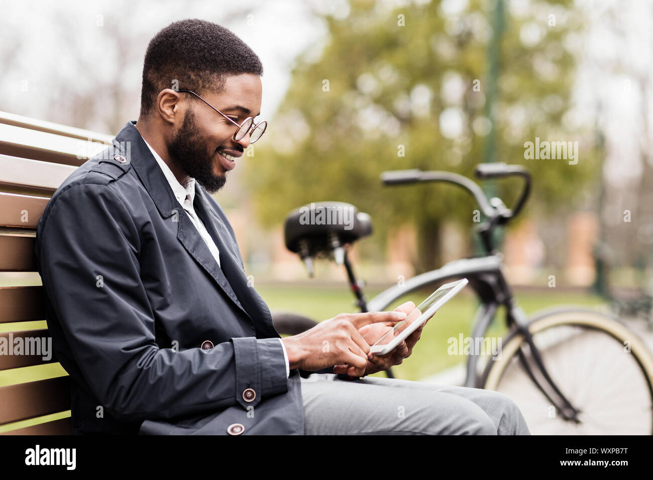 Freelance work. Young man using digital tablet in park Stock Photo