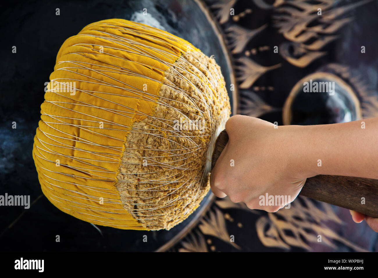 Hand hit big gong in temple Stock Photo