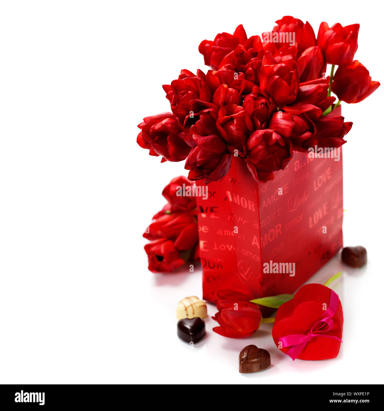 Valentine composition with shopping bag, gift box, chocolate and fresh tulips over white Stock Photo