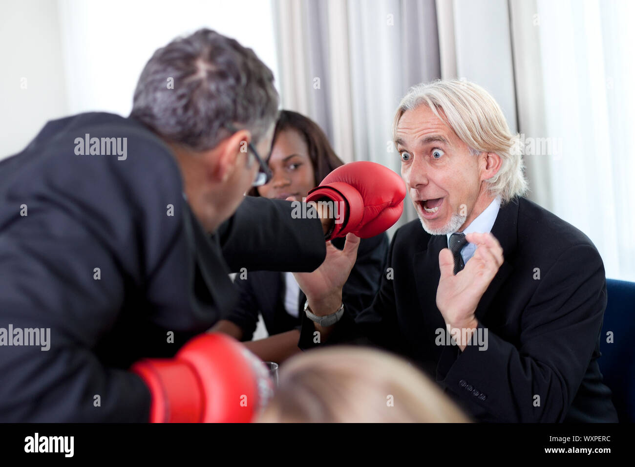 Team of business associates fighting in the office Stock Photo