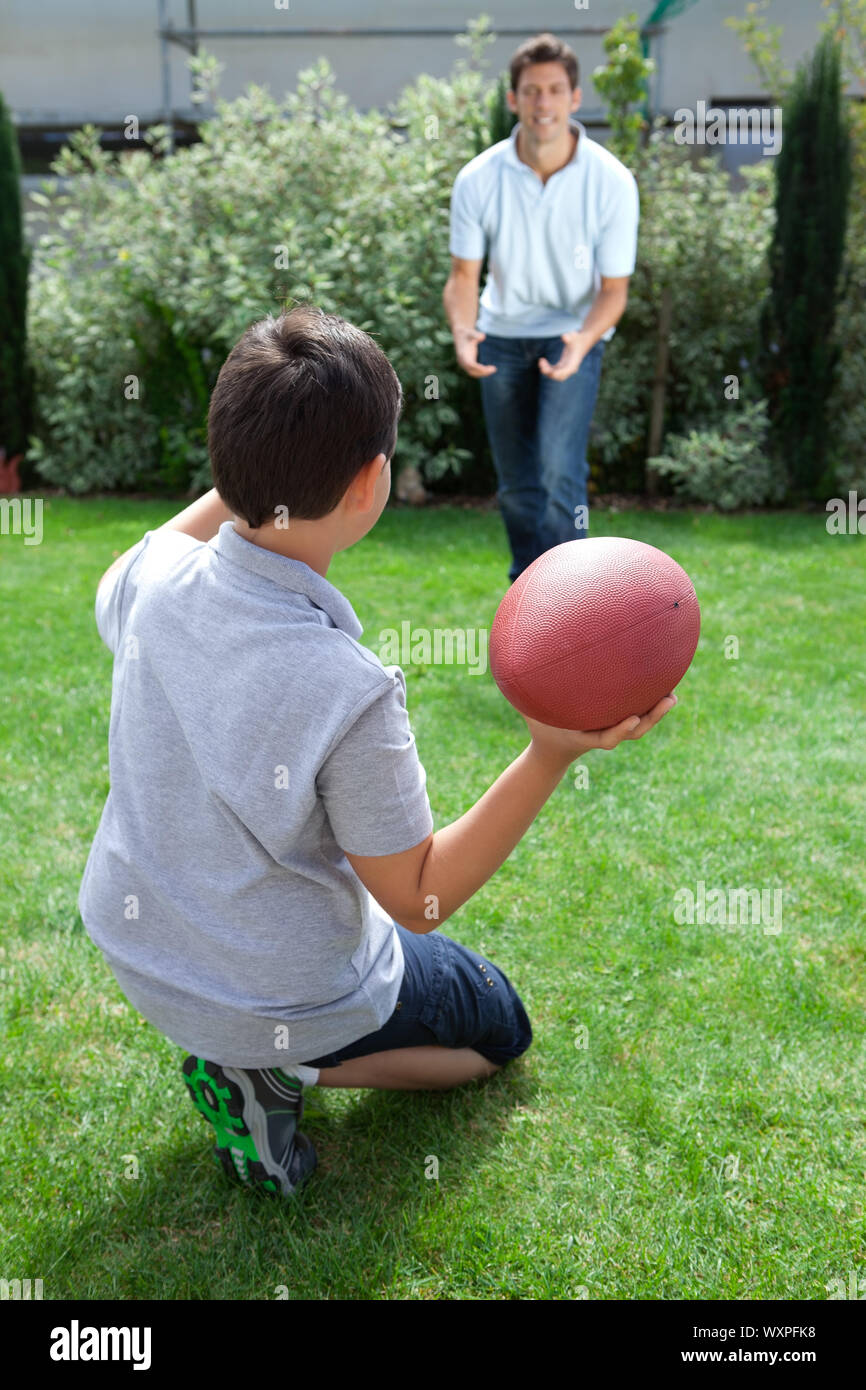Little kid throwing football to his father in backyard Stock Photo Alamy