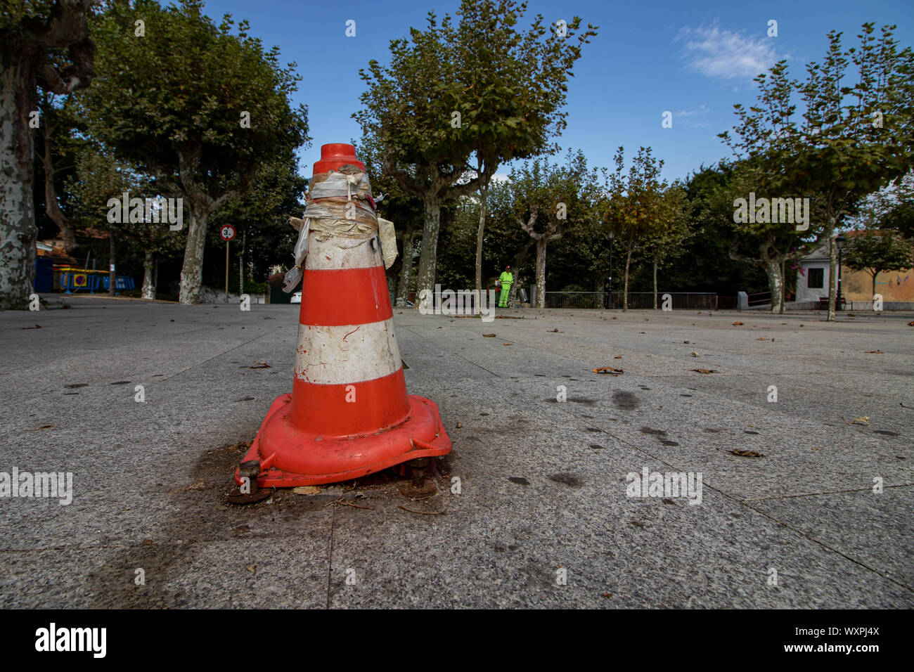 Cambre / Spain - September 16 2019: Old Red and white traffic cone covering the mounting plate for a broken floodlight in a plaza in Cambre Spain Stock Photo