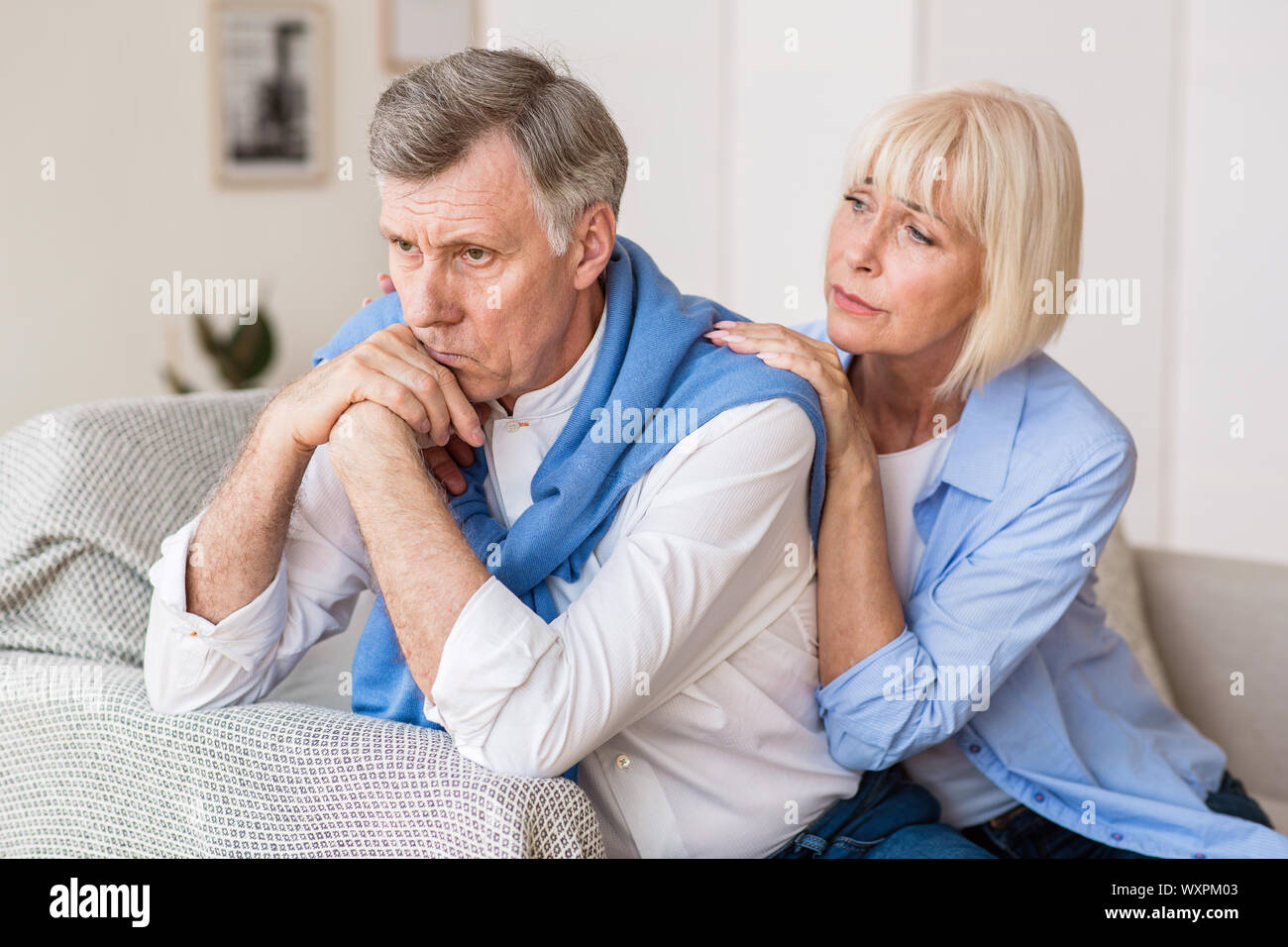 Senior woman consoling husband after arguing at home Stock Photo