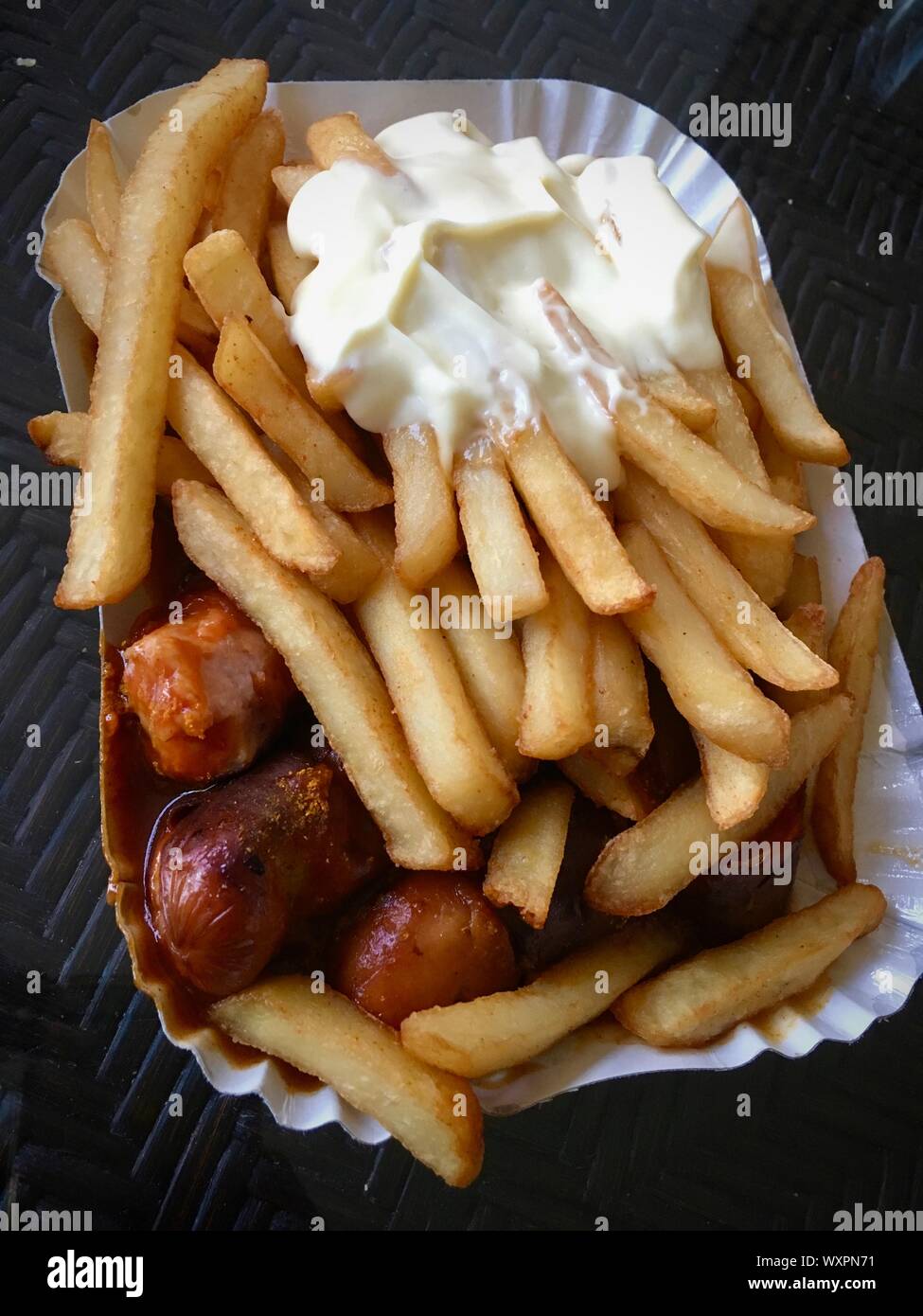 Currywurst & Pommes: Famous German Fast Food (Curry Sausage with French Fries and Curry Sauce) with ketchup and mayonaise Stock Photo