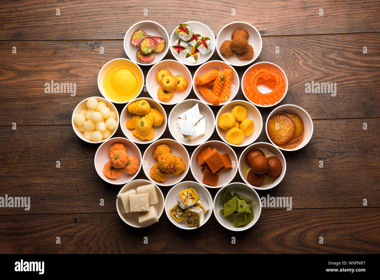 Snack Rangoli Rangoli of sweets and Farsan/snacks in bowls for Diwali with diya over ...