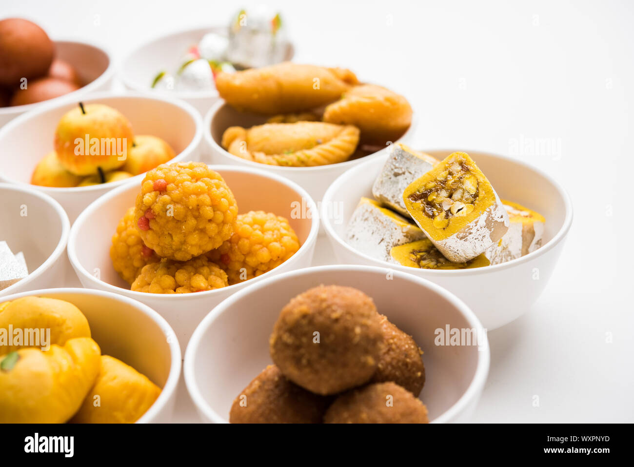 Rangoli of sweets and Farsan/snacks in bowls for Diwali with diya over