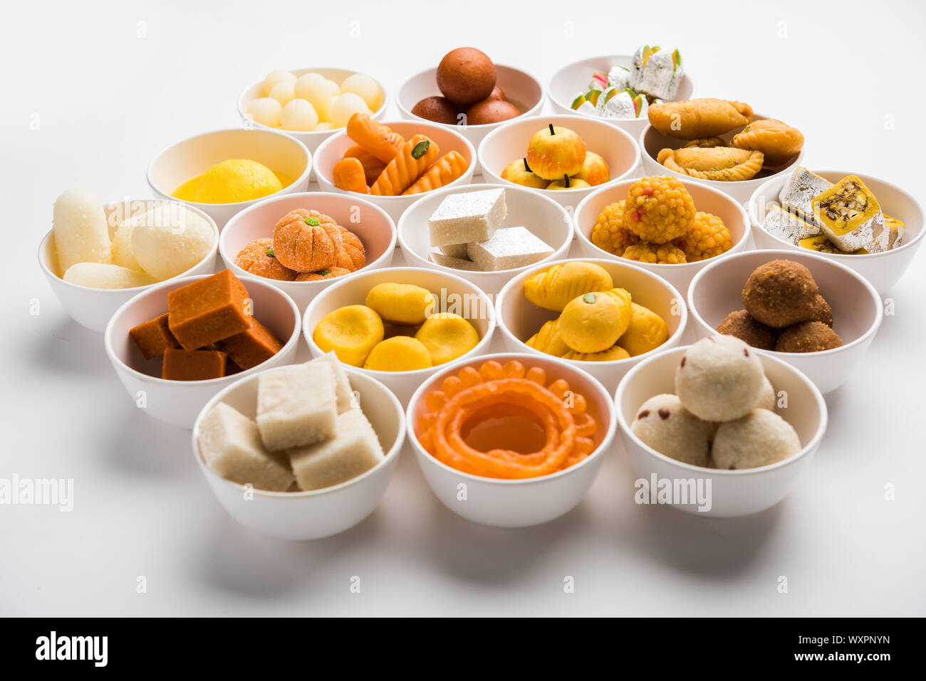 Rangoli of sweets and Farsan/snacks in bowls for Diwali with diya over