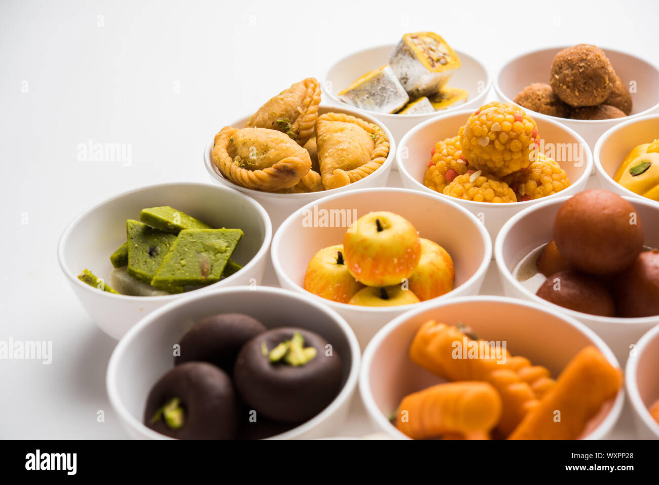 Snack Rangoli Rangoli of sweets and Farsan/snacks in bowls for Diwali with diya over ...