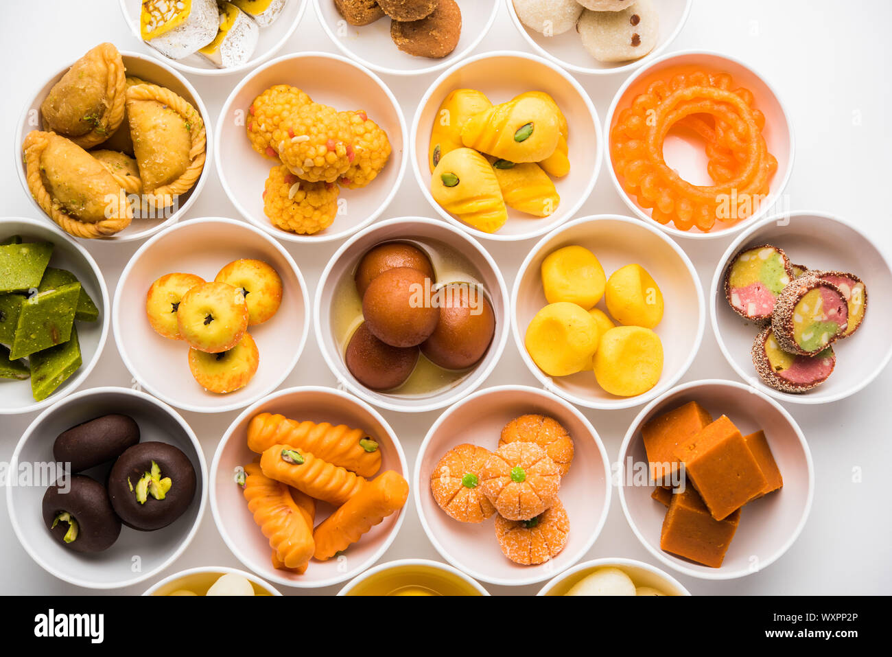 Snack Rangoli Rangoli of sweets and Farsan/snacks in bowls for Diwali with diya over ...