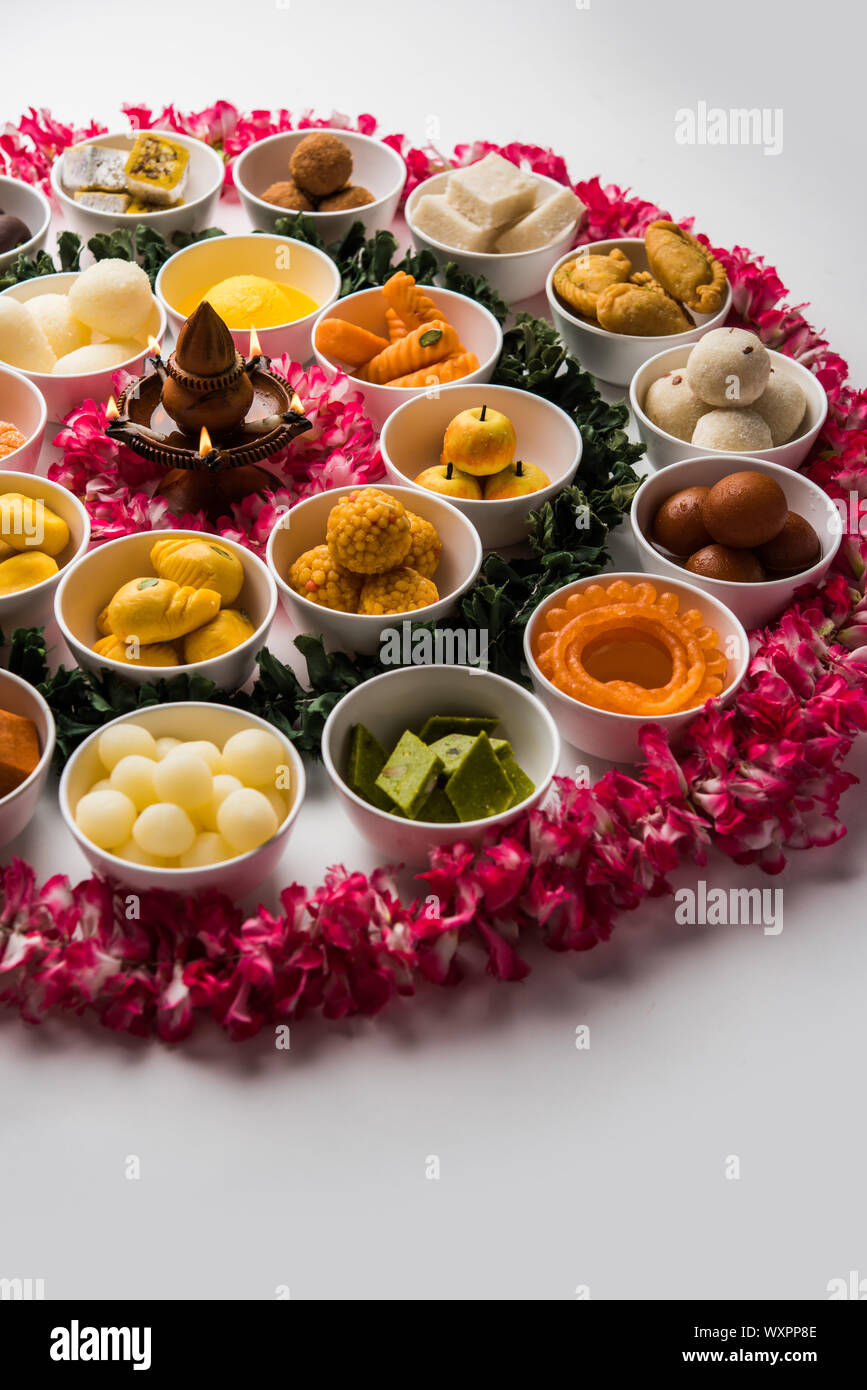 Snack Rangoli Rangoli of sweets and Farsan/snacks in bowls for Diwali with diya over ...