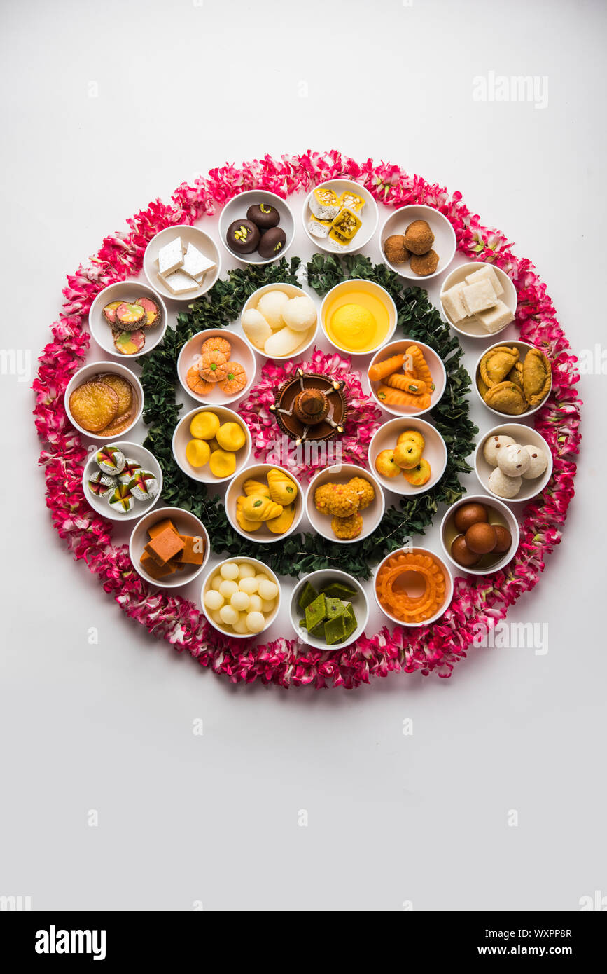 Snack Rangoli Rangoli of sweets and Farsan/snacks in bowls for Diwali with diya over ...