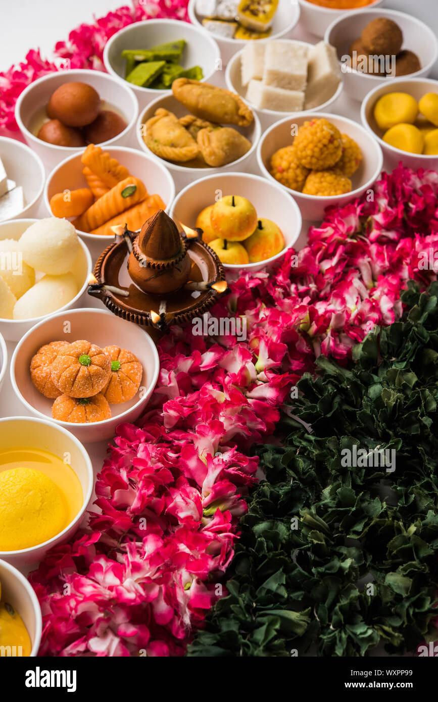 Snack Rangoli Rangoli of sweets and Farsan/snacks in bowls for Diwali with diya over ...