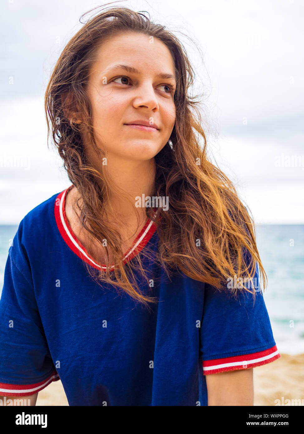 Caucasian brunette girl without makeup with wet hair in a blue t-shirt, in nature portreit Stock Photo