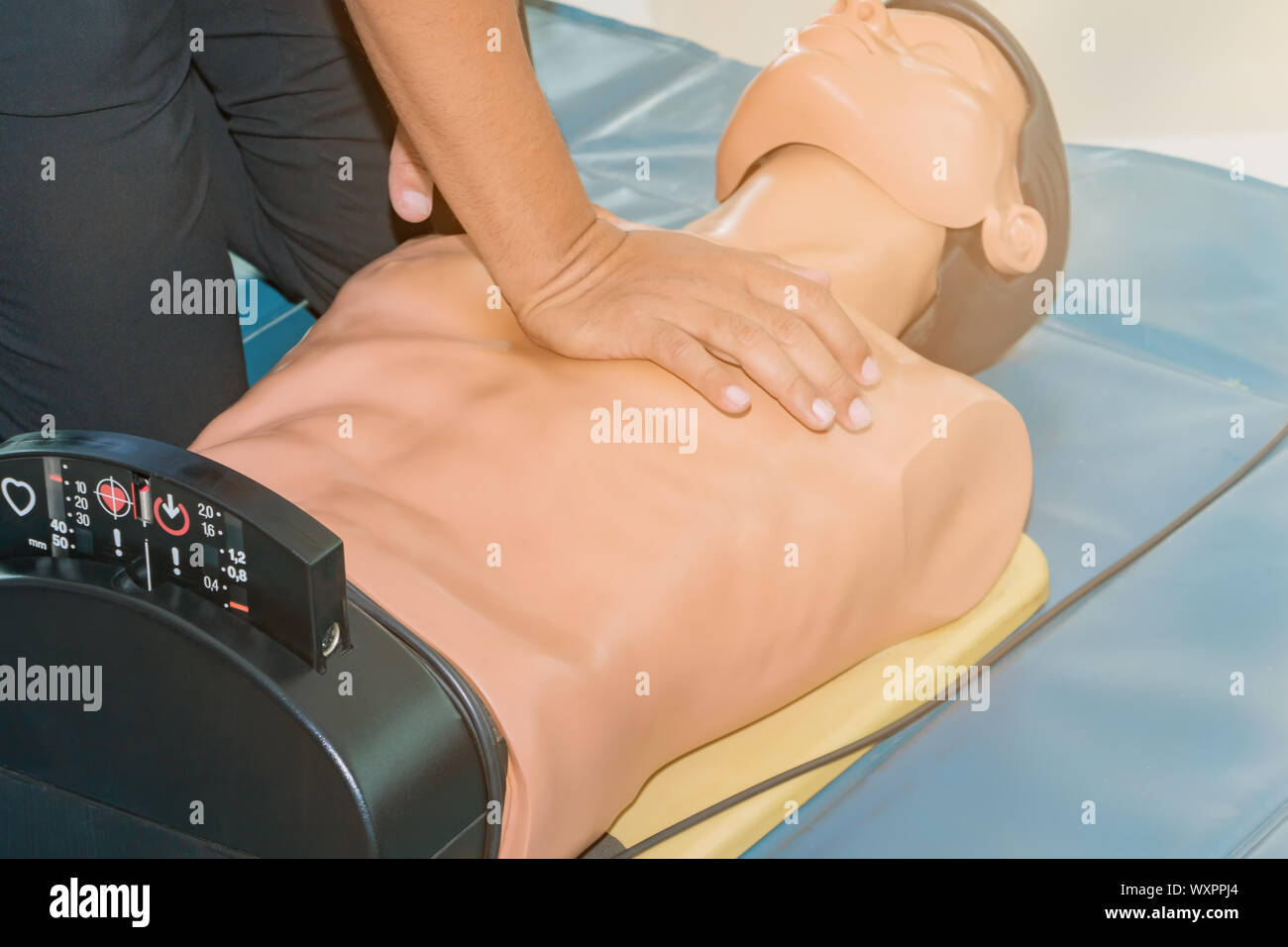 CPR aid dummy medical training with hand press Heart on doll emergency refresher training Concept closed-up. Stock Photo
