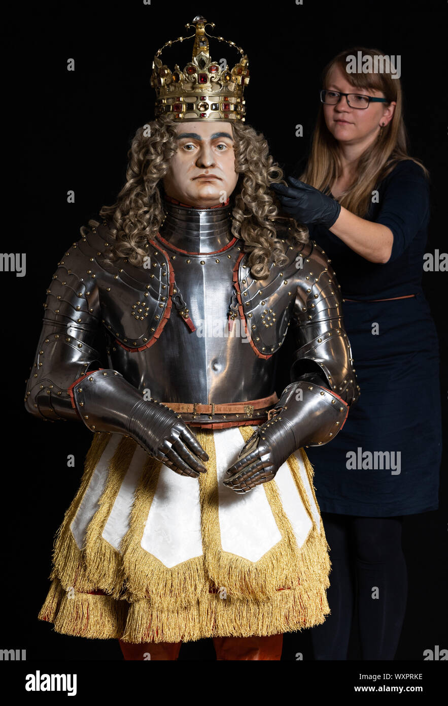 Dresden, Germany. 15th Aug, 2019. Stefanie Penthin, restorer in the armoury of the Staatliche Kunstsammlungen Dresden (SKD), works on the wig on the coronation figure of August the Strong in the coronation ornament of 1697. The figure will be an exhibit of the new exhibition in the royal parade rooms of the Residenzschloss. Credit: Robert Michael/dpa-Zentralbild/dpa/Alamy Live News Stock Photo