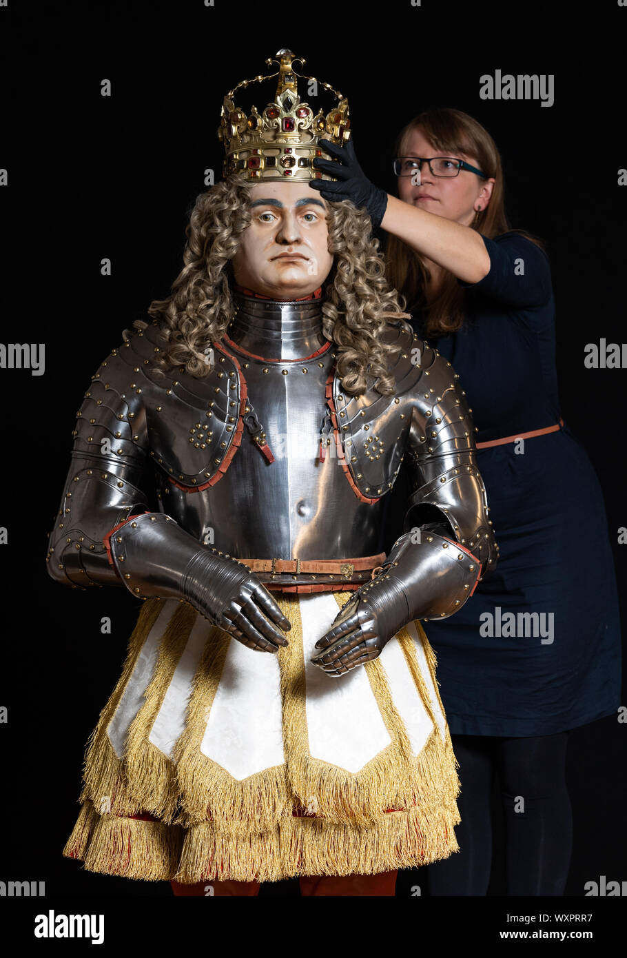 Dresden, Germany. 15th Aug, 2019. Stefanie Penthin, restorer in the armoury of the Staatliche Kunstsammlungen Dresden (SKD), crowned the coronation figure of August the Strong in the coronation ornament of 1697. The figure will be an exhibit of the new exhibition in the Royal Parade Rooms of the Residence Palace. Credit: Robert Michael/dpa-Zentralbild/dpa/Alamy Live News Stock Photo