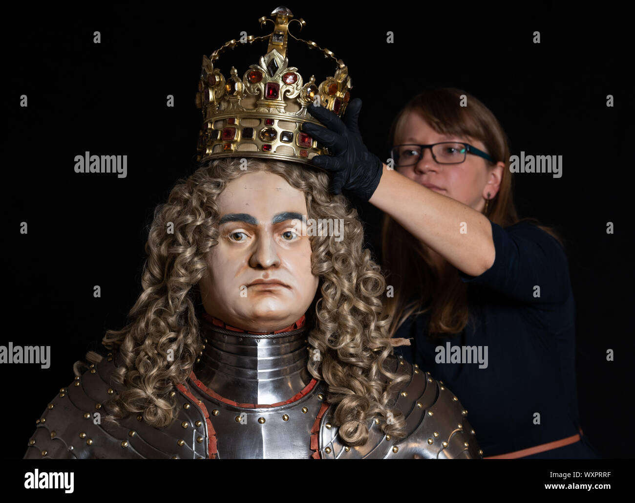 Dresden, Germany. 15th Aug, 2019. Stefanie Penthin, restorer in the armoury of the Staatliche Kunstsammlungen Dresden (SKD), crowned the coronation figure of August the Strong in the coronation ornament of 1697. The figure will be an exhibit of the new exhibition in the Royal Parade Rooms of the Residence Palace. Credit: Robert Michael/dpa-Zentralbild/dpa/Alamy Live News Stock Photo