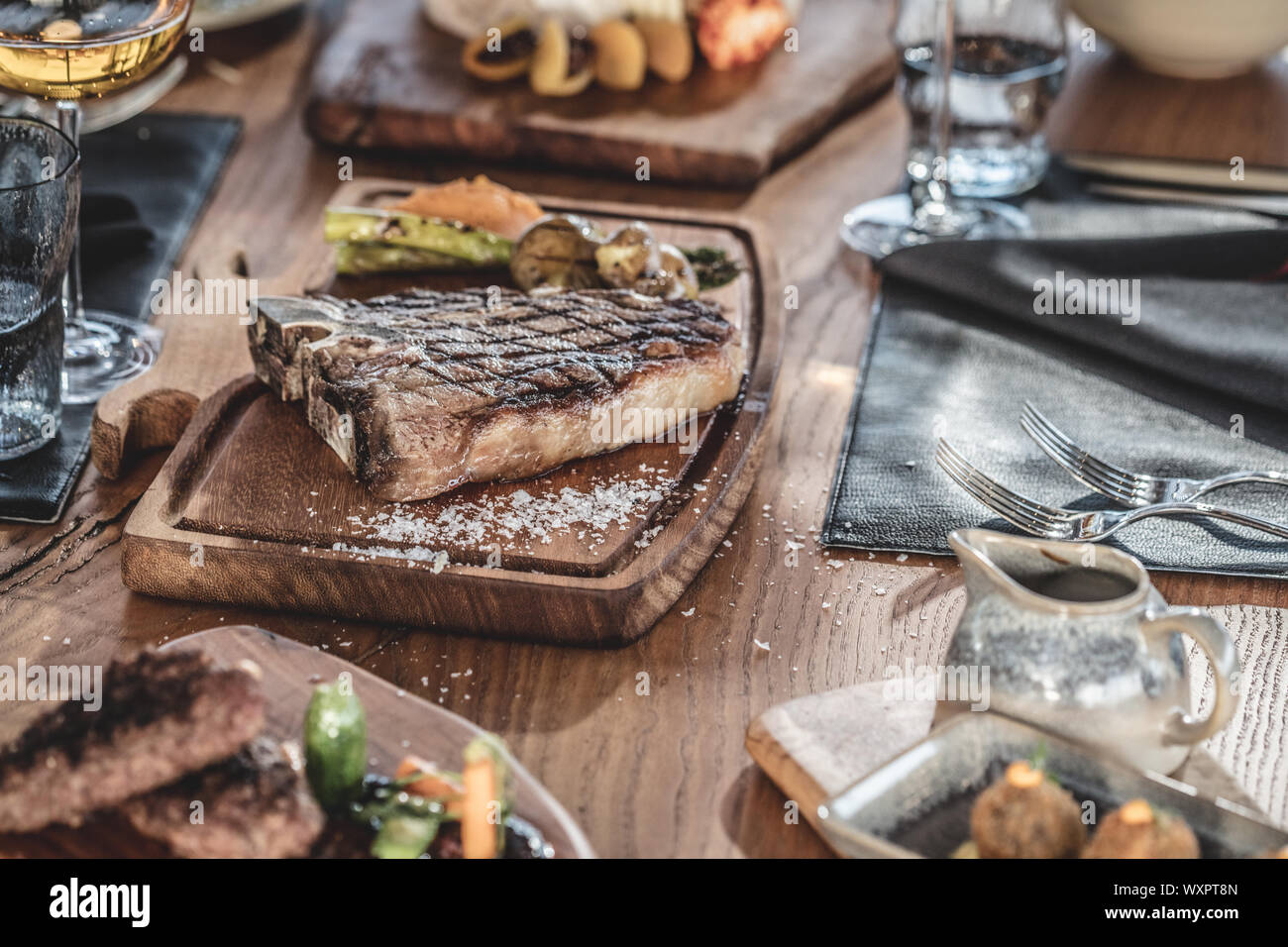 Barbecue beef t-bone  steak  served on wooden serving plate with wine and grilled vegetables Stock Photo