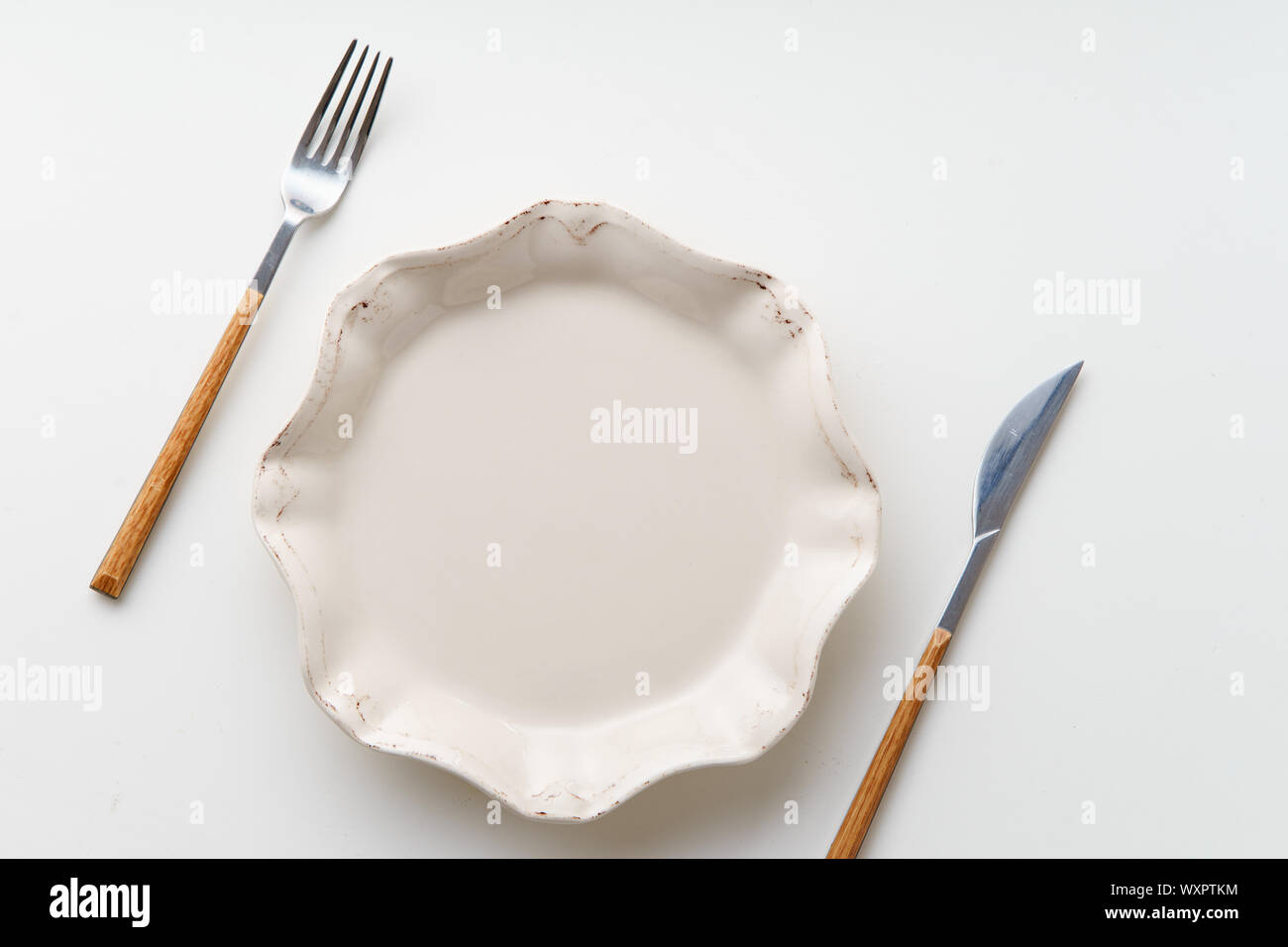 White empty plate with knife and fork on white background Stock Photo ...