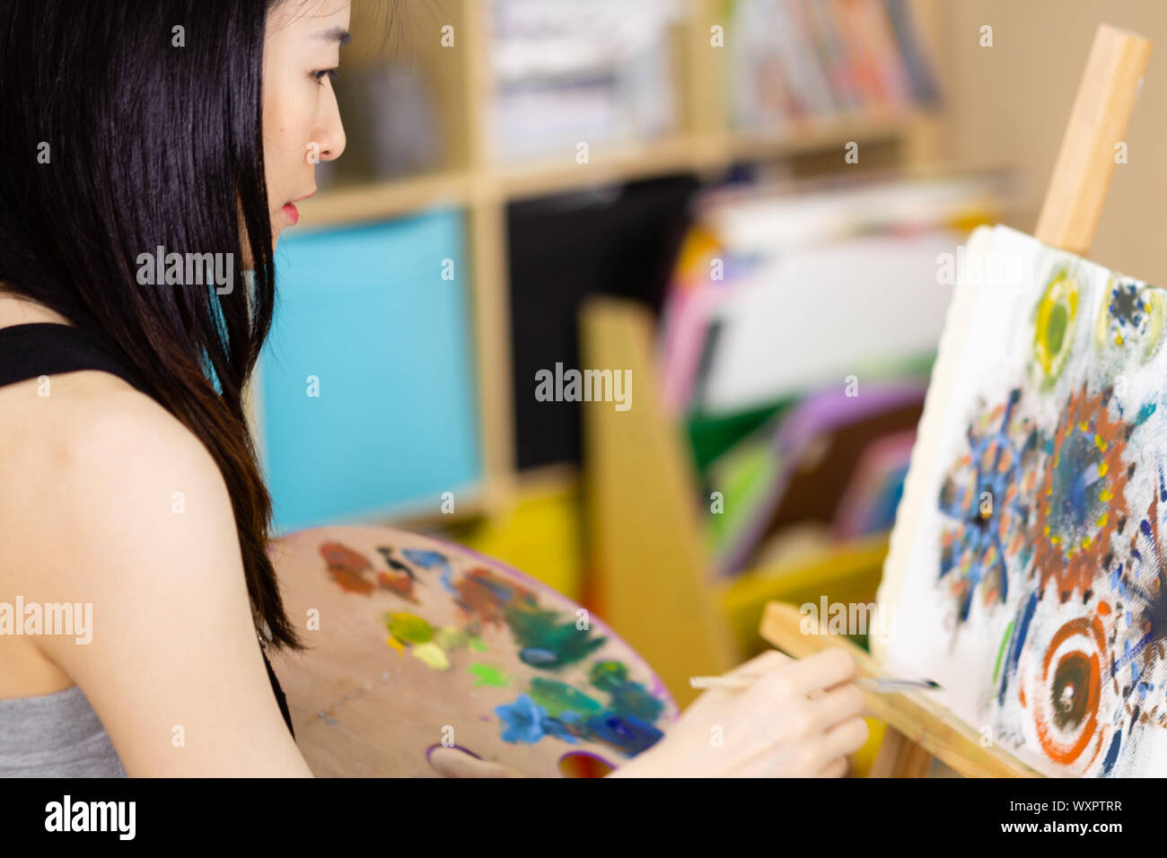 Artist painting oil painting on an easel Stock Photo