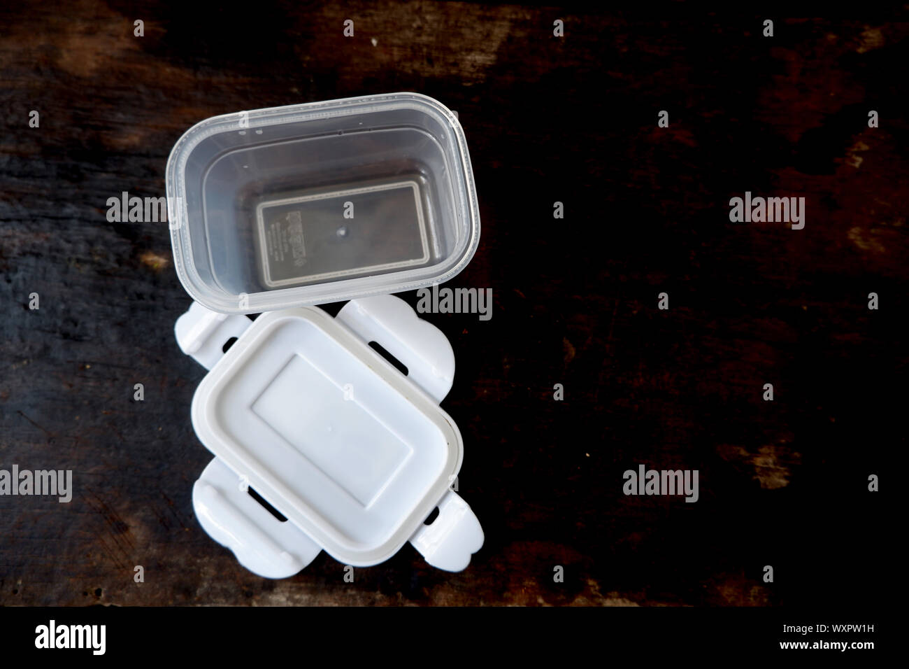 Empty plastic boxes for food storage On black wood floor Stock Photo