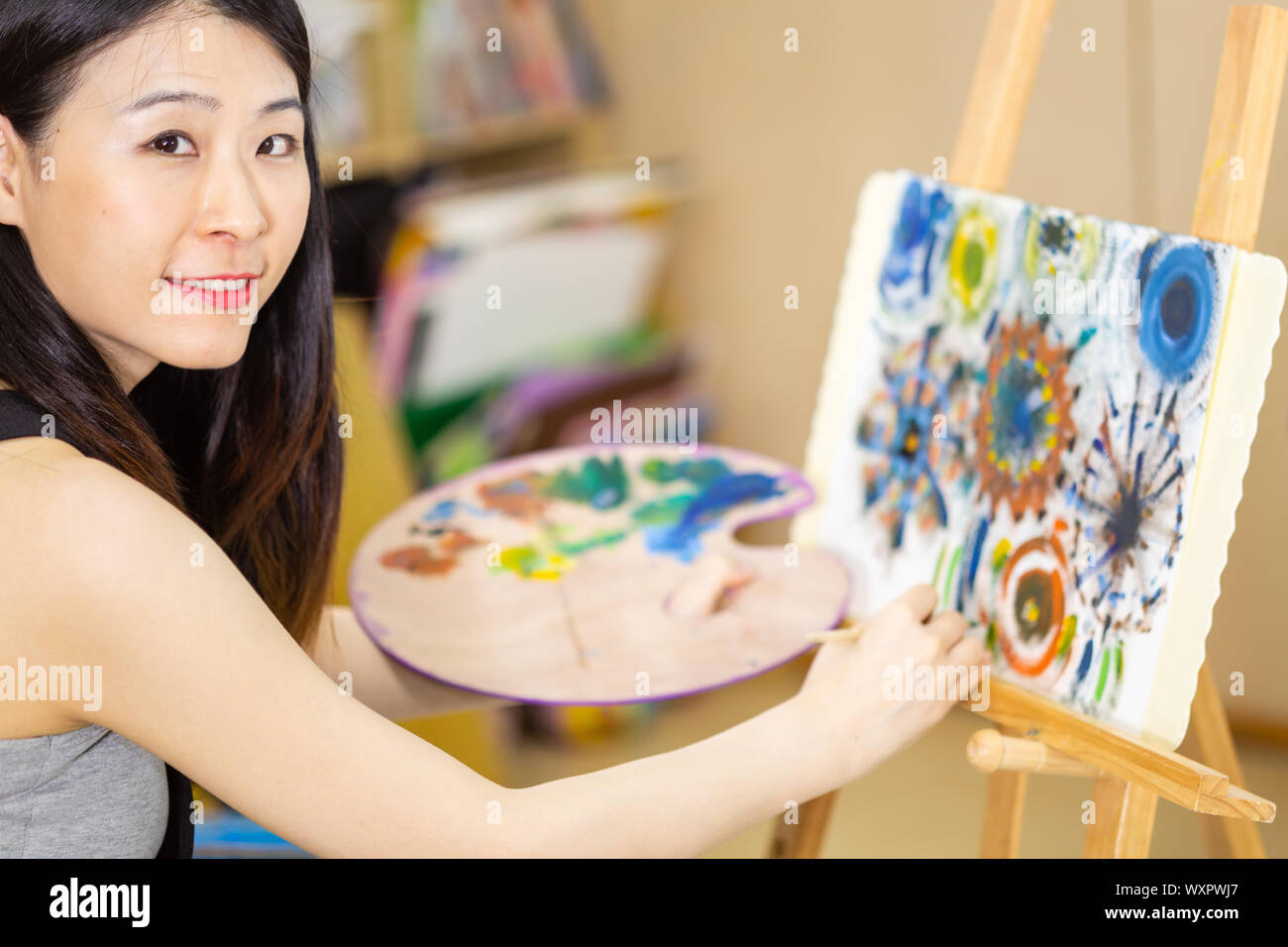 Artist painting oil painting on an easel Stock Photo
