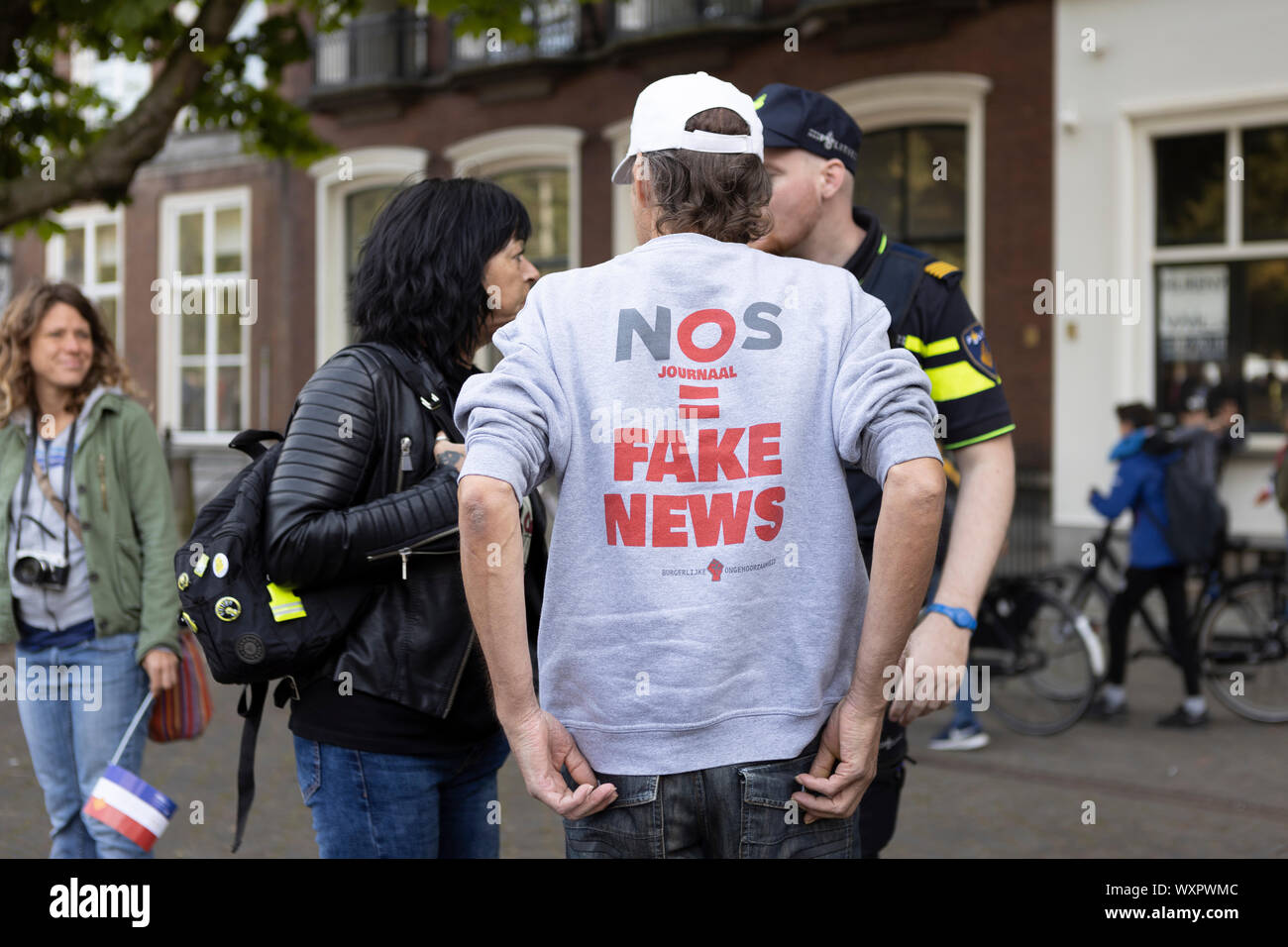 Protester with a shirt with the phrase NOS (national news broadcast) equals fake news on Prinsjesdag in Den Haag is being asked to leave by the police Stock Photo